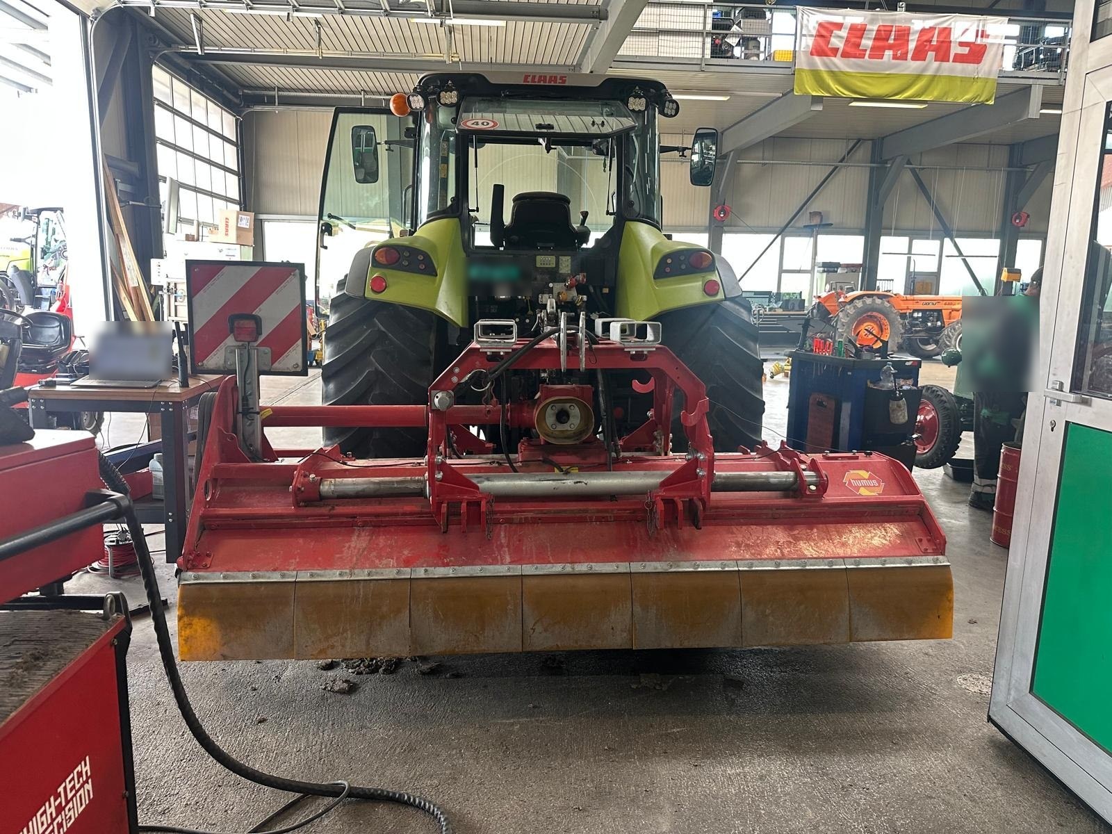 Schlegelmulcher am Traktor montiert, bereit zum Wuchten in der Hofwerkstatt